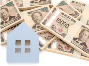 住宅模型と一万円札の束・住宅費用イメージ